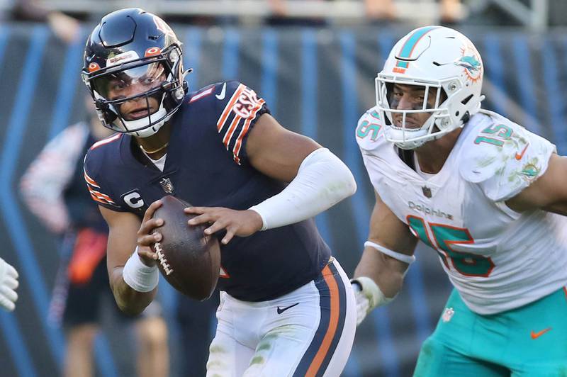 Chicago Bears quarterback Justin Fields runs away from Miami Dolphins linebacker Jaelan Phillips late in the game against the Dolphins Sunday, Nov. 6, 2022, at Soldier Field in Chicago.