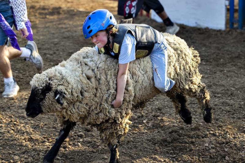 Sailor Magne, 7, of Dixon holds on during the mutton busting event Thursday, August 7, 2025, at Carroll County Fair’s T and A Bucking Bulls Rodeo.