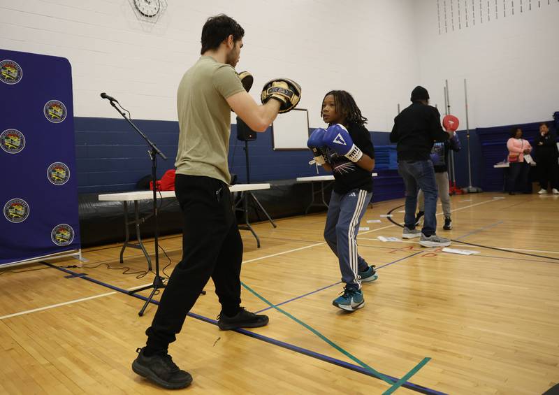 Isaiah Woods, right, does a boxing demonstration for Groves Boxing & Fitness during the Will County’s annual Kids Fair at Troy Middle School on Monday, Feb. 16, 2026 in Joliet.