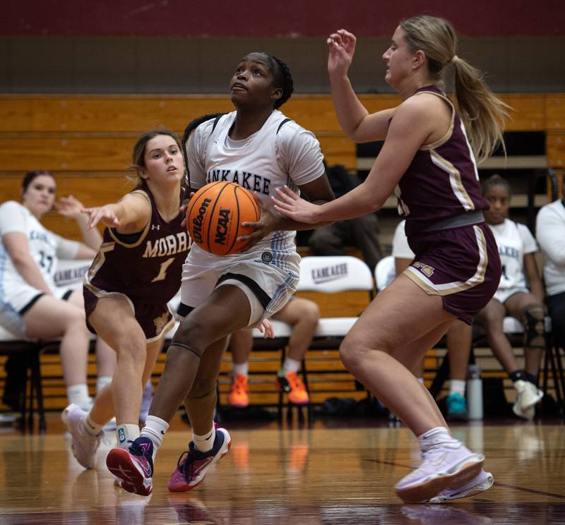 Kankakee's London Stroud, center, makes a drive toward the net as Morris's Cami Pfeifer, left, and Alyssa Jepson, right, guard in a game on Tuesday, January 27, 2026.