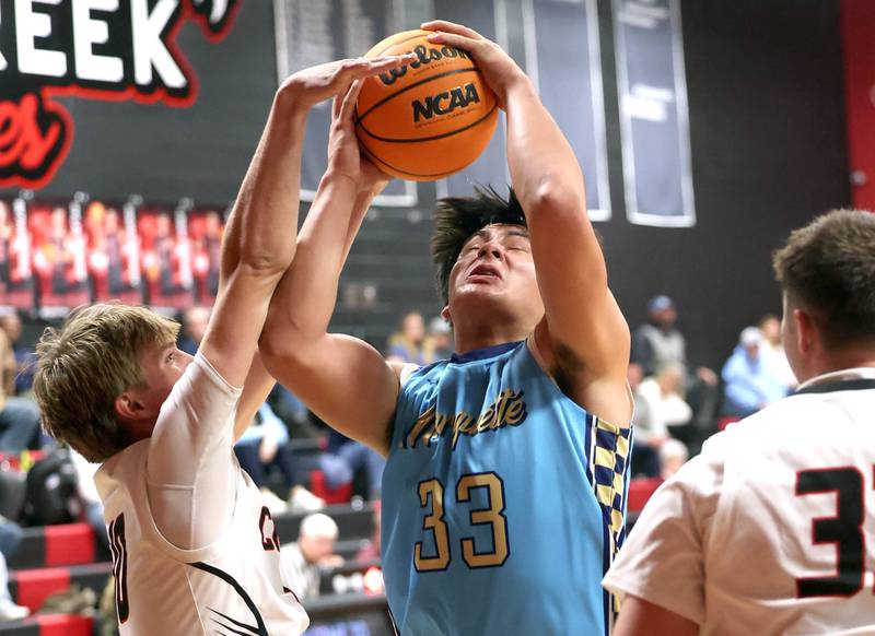 Marquette’s Blayden Cassel grabs a rebound over Indian Creek's Parker Murry Monday, Dec. 9, 2025, during their game at Indian Creek High School in Shabbona.