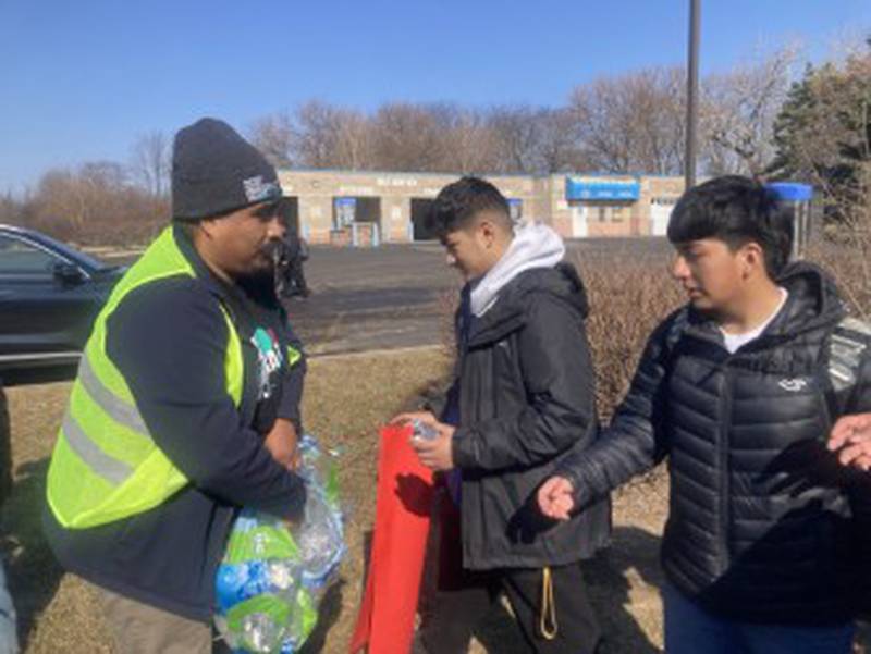 Jose E Vera, executive director of the Southwest Suburban Immigrant Project, hands out bottles of water to Bolingbrook High School students during a protest against Immigration of Customs Enforcement actions on Friday, Feb. 13, 2026. Hundreds of Bolingbrook students walked out of school to stage the protest.