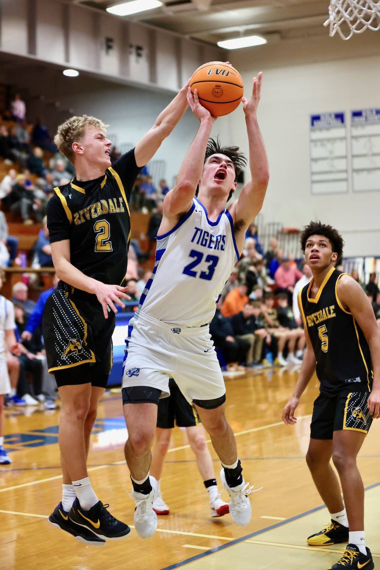 Princeton's Noah LaPorte shoots despite the presence of Riverdale's Jackson Tegeler Tuesday night at Prouty Gym. The Tigers won 67-60.