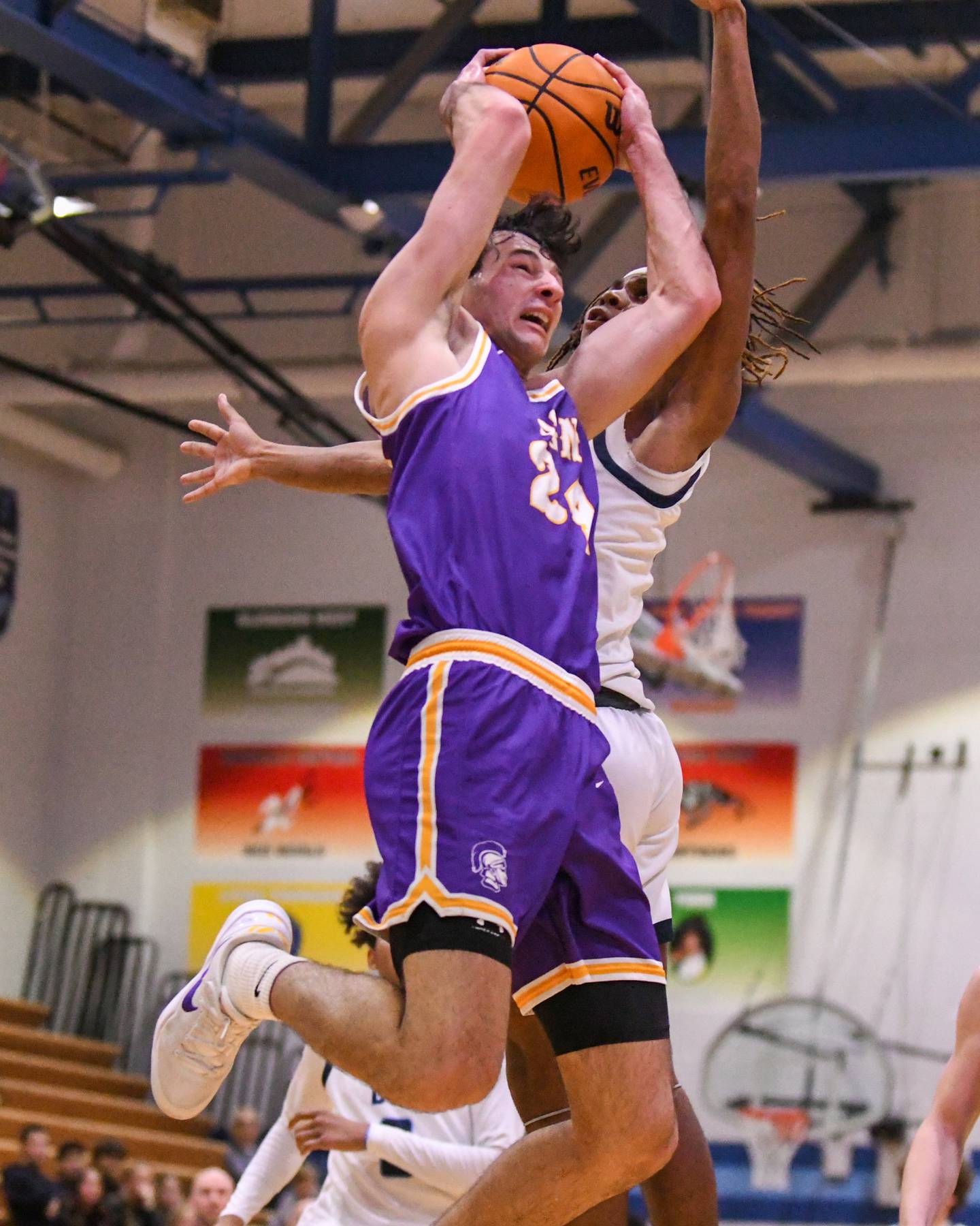Downers Grove North's Aidan Akkawi (24) gets his shot blocked by Downers Grove South's Keon Maggitt (1) during the game on Saturday Dec. 21, 2024, held at Downers Grove South High School.
