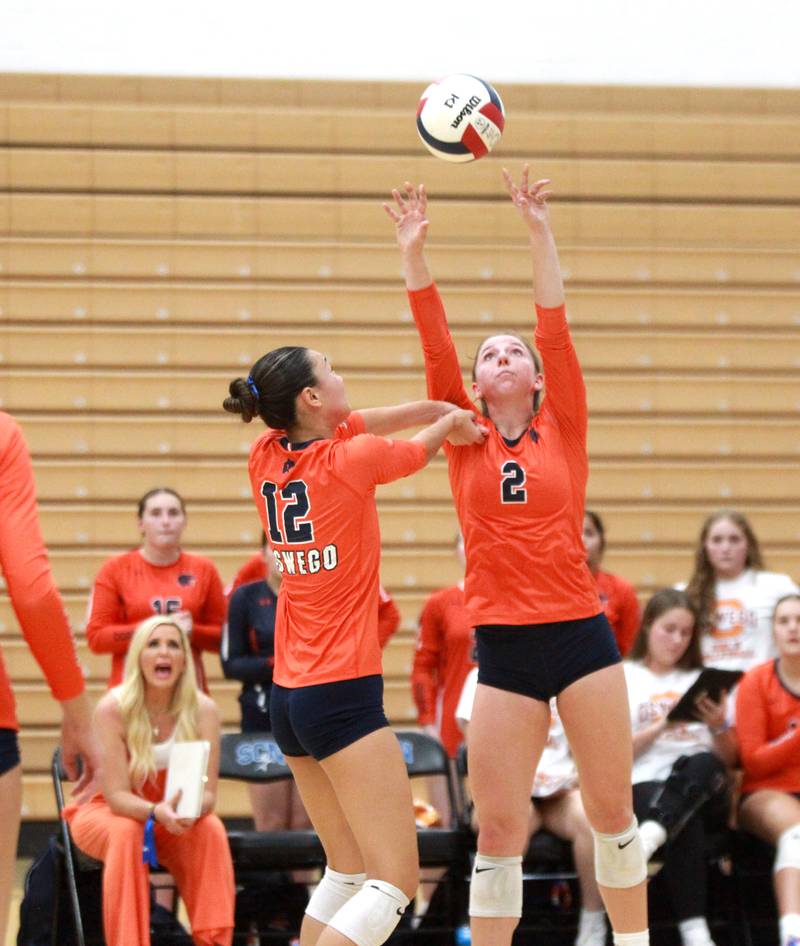 Oswego’s Kelsey Foster (2) sets the ball over teammate Ava Flanigan (12) during a game Wednesday, Sept. 18, 2024 at St. Charles North.
