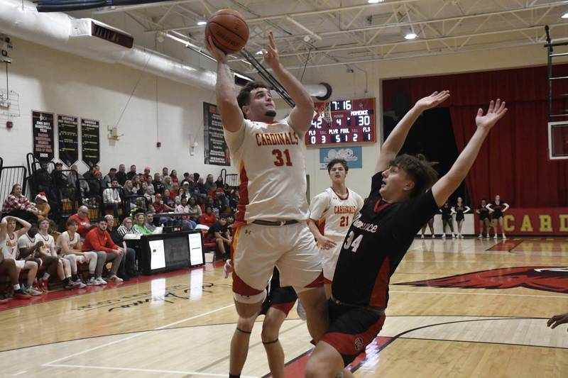 St. Anne's Brandon Schoth shoots a layup while being guarded by Momence's Jackson Ford during St. Anne's 61-46 victory over Momence on Tuesday December 9, 2025.