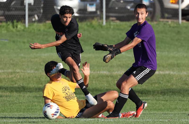 DeKalb and Sycamore players get tangled up going after a loose ball Wednesday, July 17, 2024, during their scrimmage at Sycamore High School.