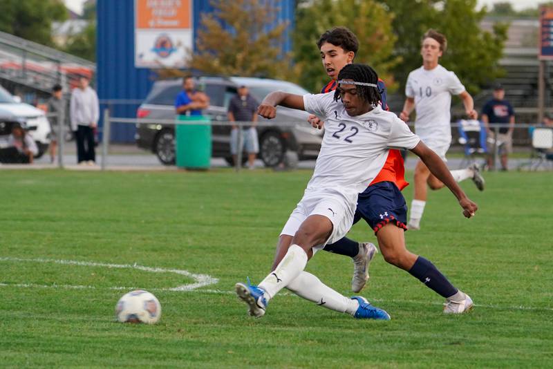 Oswego East's Marlin Hoffman (22) shoots the ball against Oswego during a soccer match at Oswego High School on Tuesday, Oct. 1, 2024.