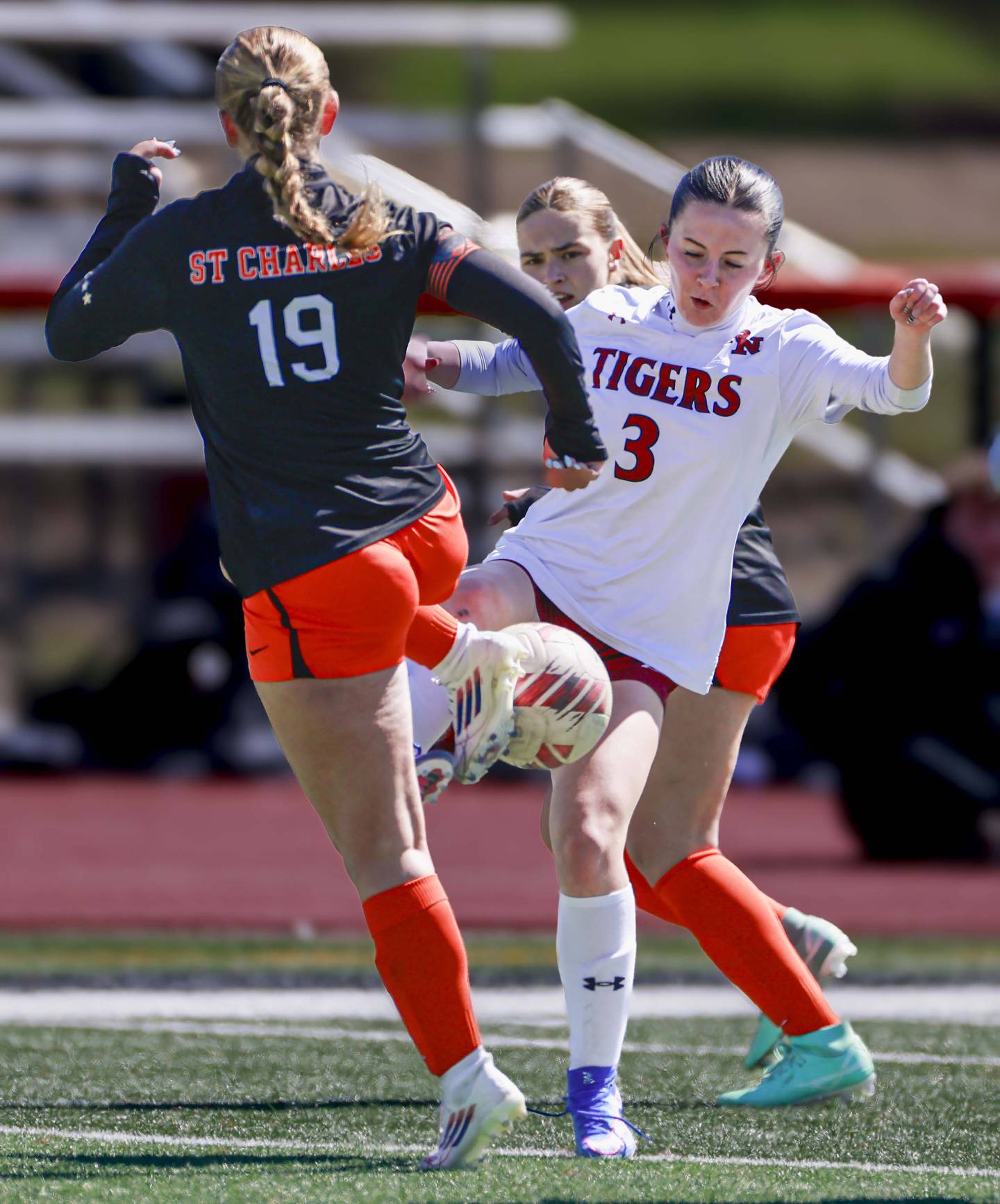 St. Charles East’s Tatum Smith (19) pressure Plainfield North’s Nora Roche, (3) Saturday, March 28, 2026 during the Championship game of the St. Charles East girls soccer invitational.