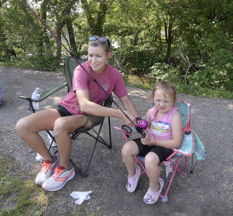 Kelly Ryan helps her daughter Lennon reel in a bite on her line Saturday, June 3, 2023, at Lock 14 in LaSalle during the 36th annual Kid's Fishing Tournament.