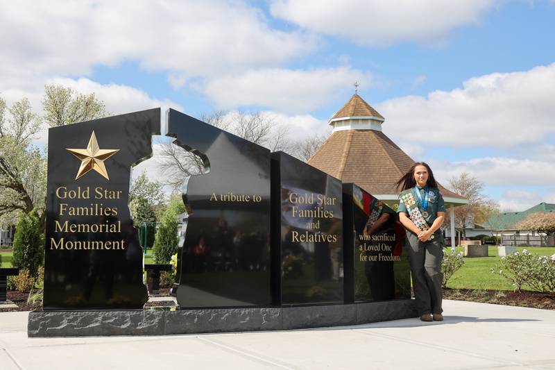Alexis McCullough, 17, of Bourbonnais, stands next to the new Gold Star Families Memorial Monument, which she successfully completed for her Eagle Scout project, during the dedication ceremony at Marcotte Park in Bourbonnais on Saturday, April 26, 2025.
