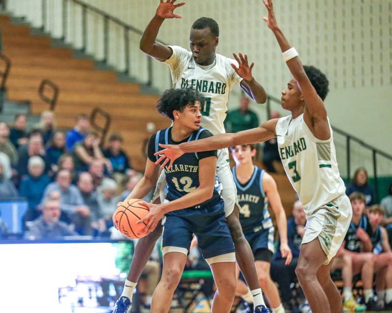 Nazareth's Rasim Johnson (12) is defended at half cour by Glenbard West's Josh Abushanab (10) and  TJ Williams (3)during their Jack Tosh Holiday Classic basketball tournament game between Nazareth vs Glenbard West. Thursday Dec 26, 2024 in Elmhurst.
