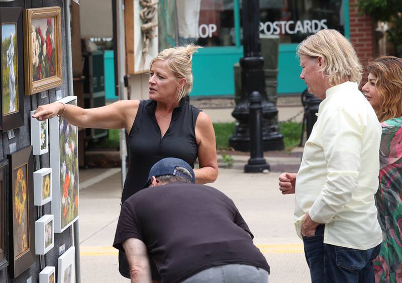 Visitors check out the work of one of the artists Saturday, July 26, 2025, during the Geneva Arts Fair in downtown Geneva.