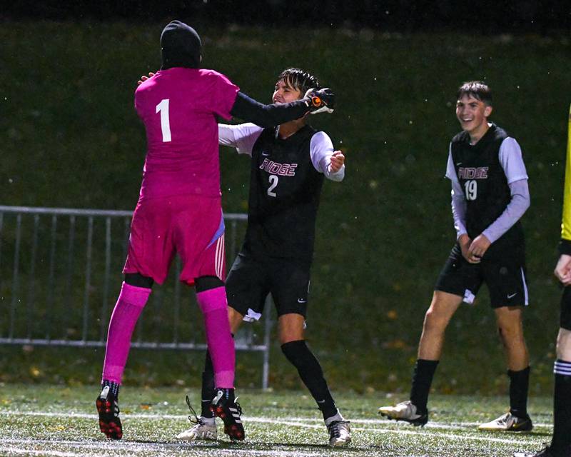 Prairie Ridge's goalkeeper Christopher Zinevich (1) runs across the field to celebrate with teammate Logan Braun (2) after Nicolas Flaugher scores a goal while taking on Benet Academy during the class 2A super sectional soccer match on Tuesday Nov. 5, 2024, held at Wheaton Academy in West Chicago.