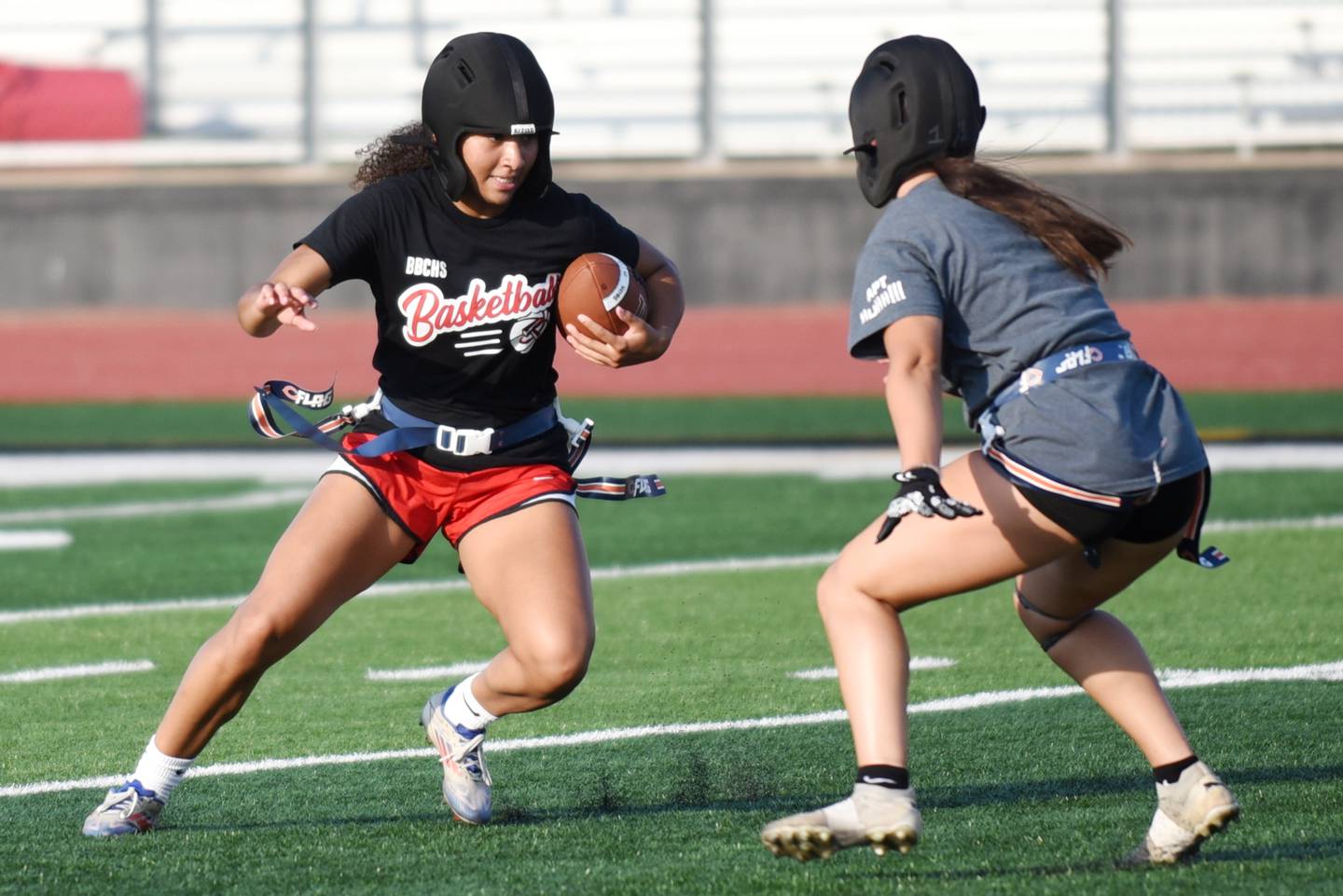 Bradley-Bourbonnais senior Nia Lawrence, left, looks for a way around teammate Callie Andrews during the school's flag football camp Wednesday, July 2, 2025.