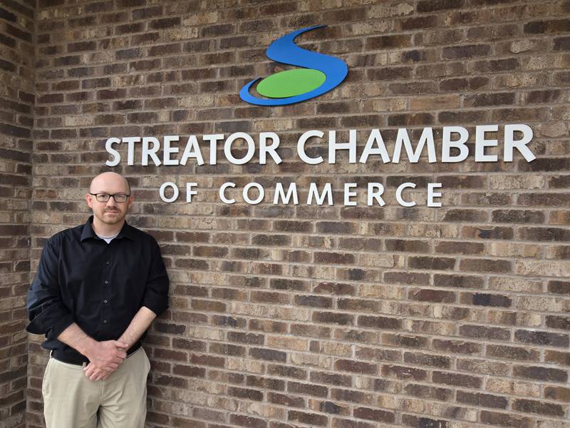 Derek Barichello poses for a photo in front of the Streator Chamber of Commerce building as he begins his new roles as executive director and facilitator of the Streator Area CEO program.