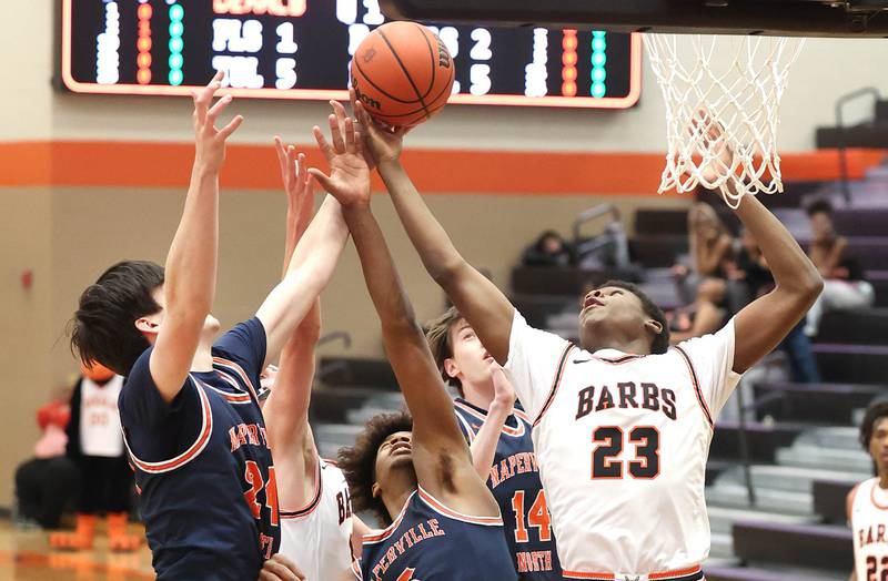 DeKalb's Davon Grant pulls a rebound away from two Naperville North defenders during their game Monday, Jan. 30, 2023, at DeKalb High School.