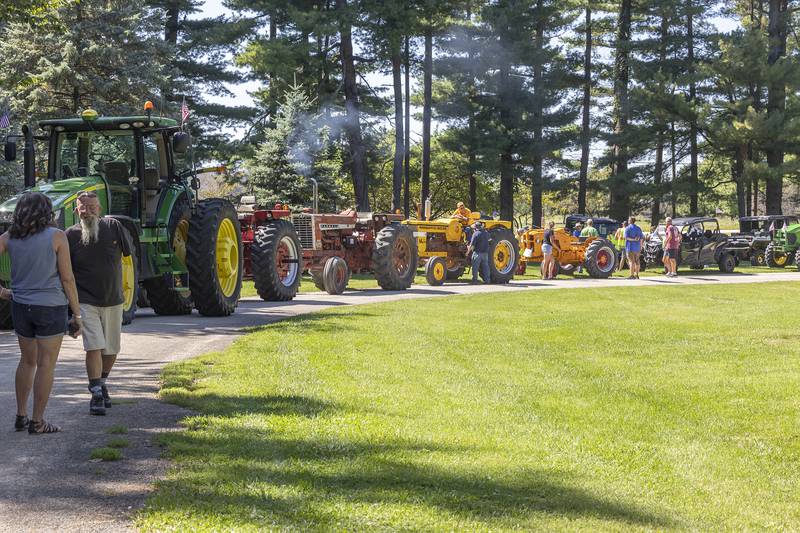 J&R Harvest Riders make a stop in Lowell Park on Saturday, Aug. 31, 2024, in Dixon. The parade had 29 tractors in this year’s ride.