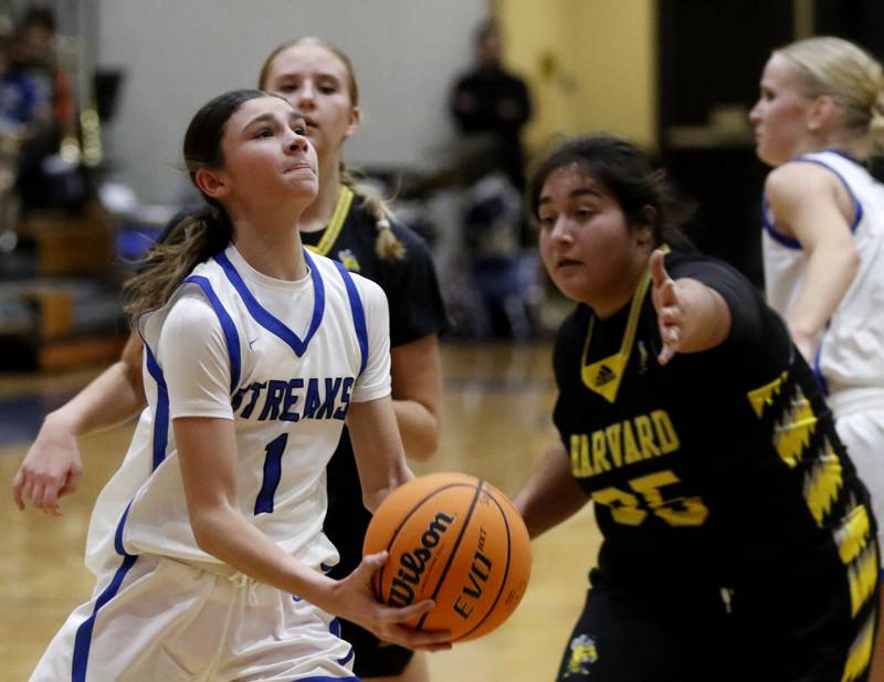 Woodstock's Alex Nowacki drives to the basket against Harvard's Crystal Gonzalez during a Kishwaukee River Conference girls basketball game on Monday Jan. 12, 2026, at Woodstock High School.