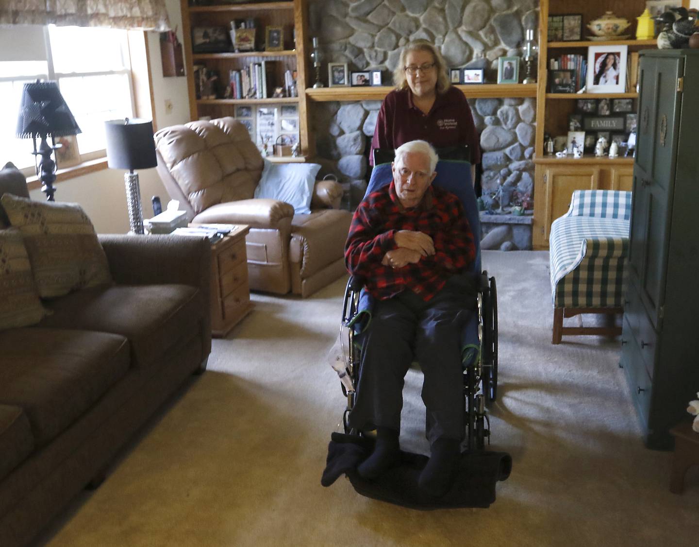 MarJo Gunnison, a home caregiver with Home Instead, helps move Joseph Seminara, 89, to another room in his Wonder Lake home on Friday, Feb. 10, 2023.