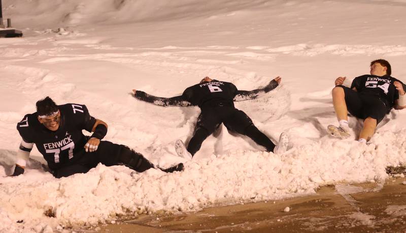 Fenwick players Logan Schultz, Noah Sur and Brennan Schultz make snow angels after winning the Class 6A State championship game on Tuesday, Dec. 2, 2025 in Hancock Stadium at Illinois State University in Normal.