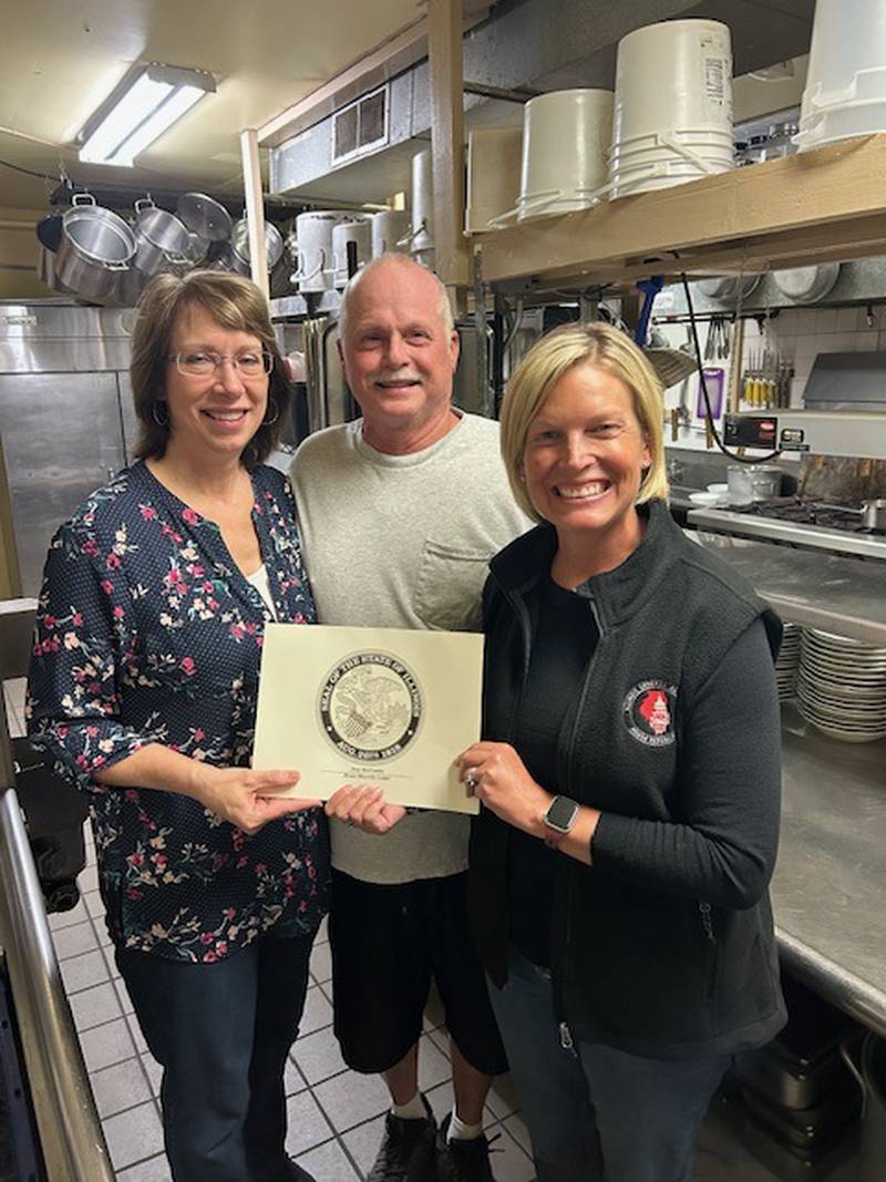 State Rep. Tony McCombie (right) presents a certificate to Beaches owners Anita and Michael Parkinson.