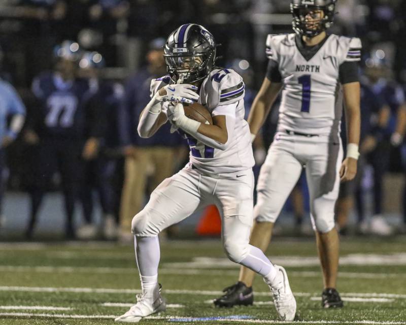 Downers Grove North's Kevin Jay Jr. (27) runs up the middle during football game between Downers Grove North at Downers Grove South Friday, Sept 5, 2025 in Downers Grove.