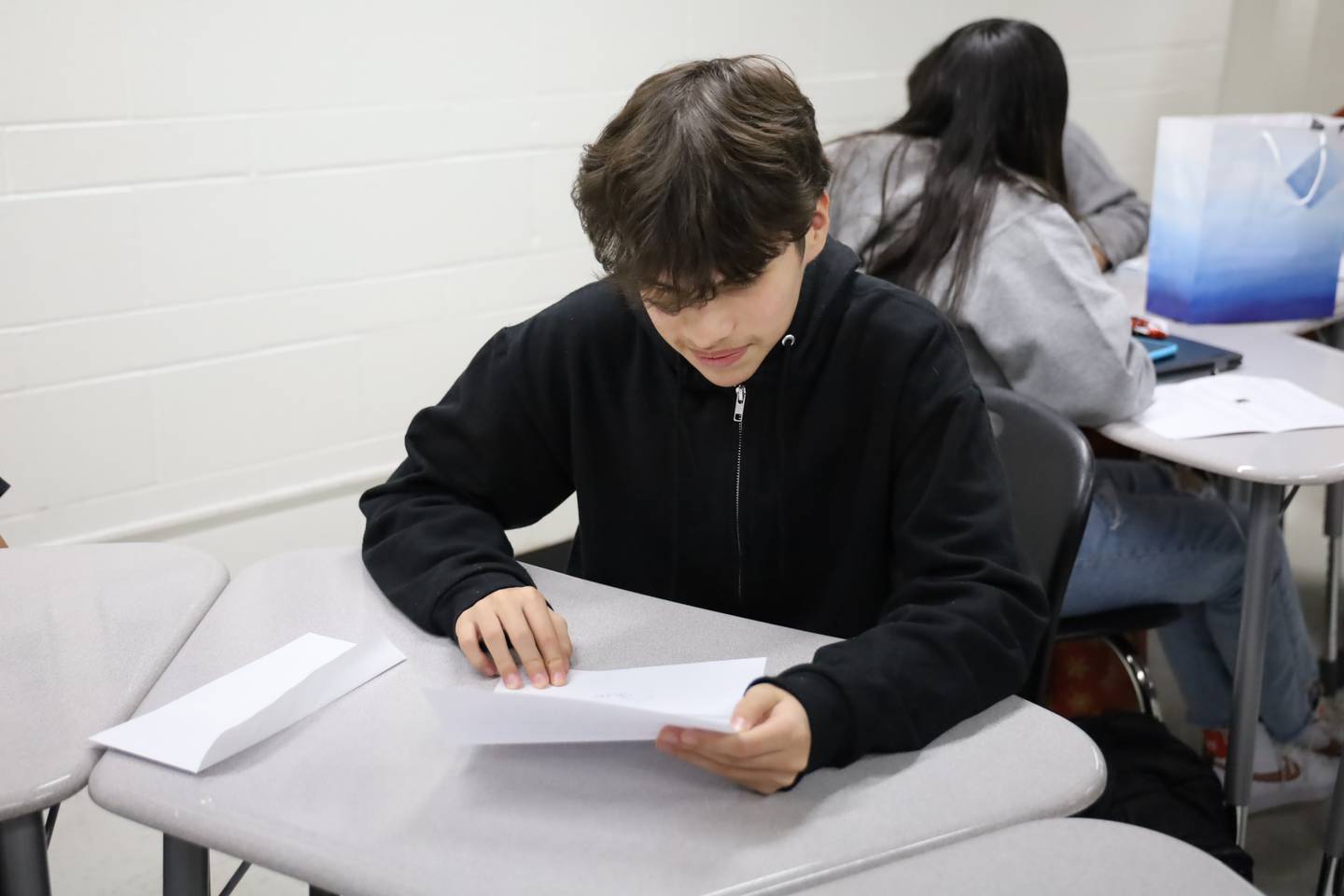 McHenry High School Sophomore Jhosmar Mujica reads a letter from his pen  pal on Tuesday, Dec. 19, 2023. The students and their pen pals have exchanged letters three times so far this school year.