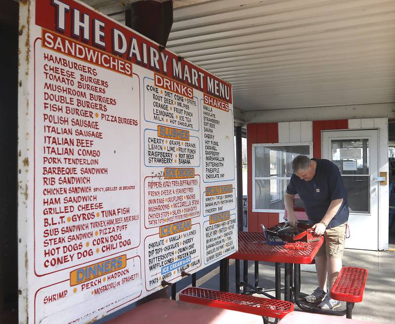 Bill Dunn, who recently purchased the Huntley Dairy Mart on Route 47 in Huntley, searches for a tool as he works with John Wean to remove the winter panels around the restaurant on Friday, April 14, 2023, as they prepare to reopen the Dairy Mart after it closed in February.