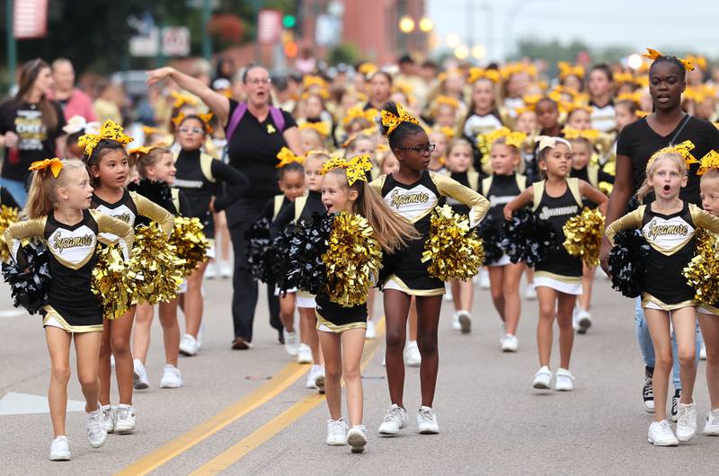 Members of the Sycamore Youth Football cheer team make their way down State Street Wednesday, Sept. 20, 2023, during the Sycamore High School homecoming parade.