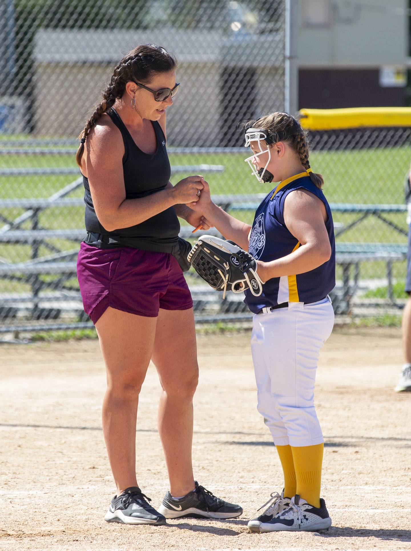 Stars coach Bryanne Callahan takes a timeout to talk with pitcher Emily Drake during the Ottawa Girls Fastpitch Association 11U city championship game at Peck Park.