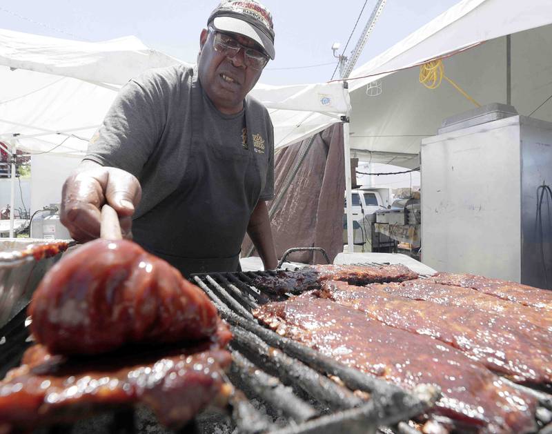Cornell Simon of Blazin Bronco prepares some ribs during opening day of Ribfest Friday June 17, 2022 at the DuPage County Fairgrounds in Wheaton.