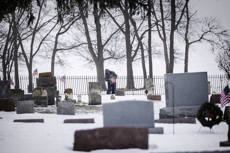 Volunteers spread out throughout the cemetery to place the wreaths on headstones Saturday, Dec. 13, 2025, in Dixon.