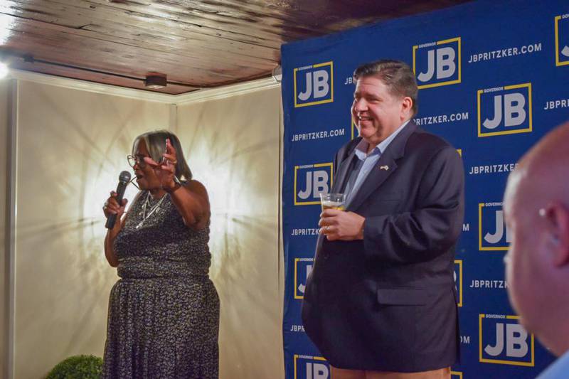 Gov. JB Pritzker holds a branded craft “JBeer” on stage at a Springfield campaign kickoff event alongside local state Sen. Doris Turner.