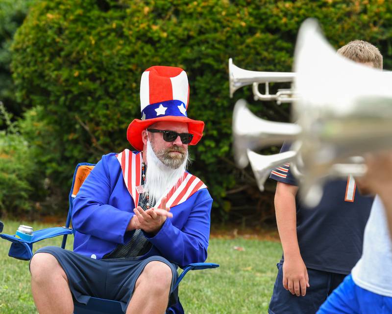 Kent Evans of Downers Grove applauds as a marching band passes by during the Downers Grove Independence Day parade held on Friday July 4, 2025, held in downtown Downers Grove.