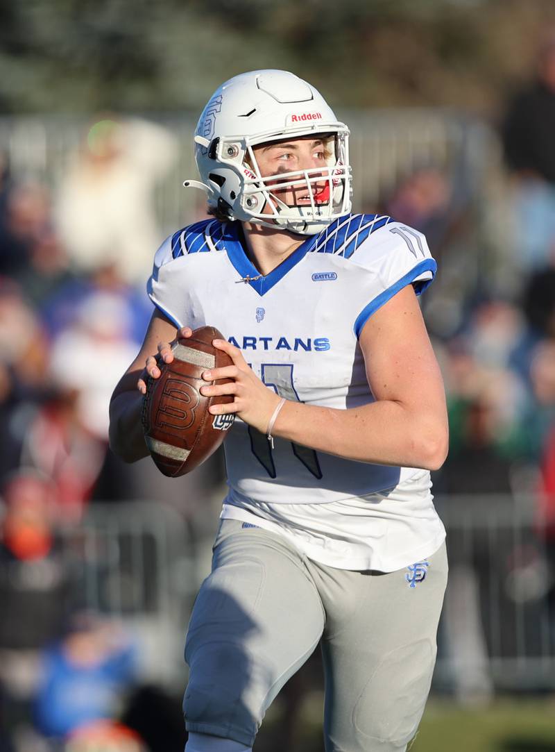 St. Francis' Alessio Milivojevic (11) looks for a receiver during the boys varsity IHSA 5A semifinal between Nazareth Academy and St. Francis high school in La Grange Park, IL on Saturday, Nov. 18, 2023.