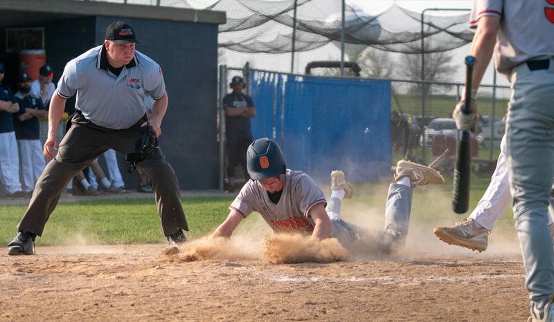 Oswego’s Chase Gerwig (2) slides into home for a score against Oswego East during a baseball game at Oswego East High School on Tuesday, May 10, 2022.
