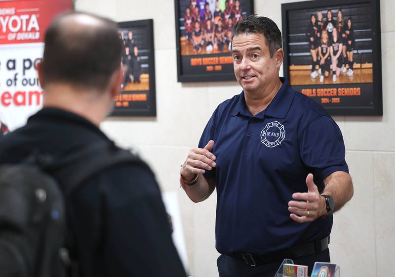 DeKalb firefighter/paramedic Pat Eriksen talks to an attendee at the City of DeKalb booth Wednesday, Oct. 22, 2025, during Trades Exploration Day at DeKalb High School. The event hosted several companies and organizations that were offering information on opportunities in the trades.