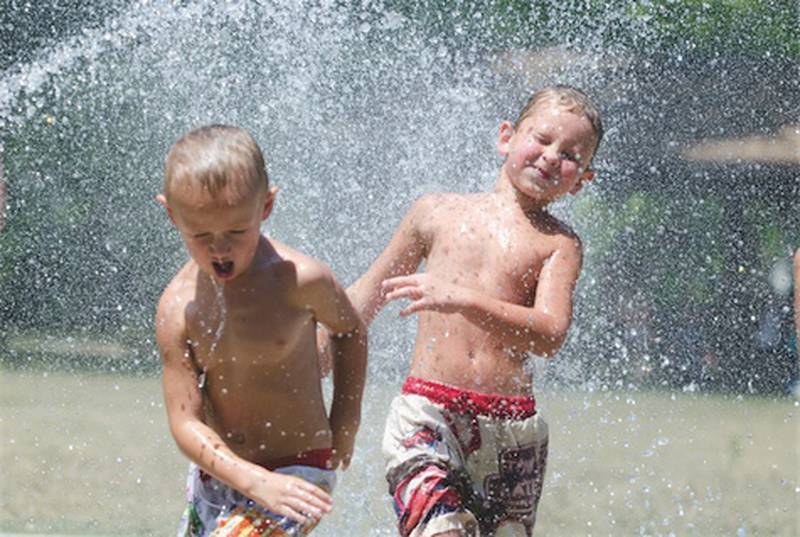 Damien Mox (left), 5 and Kaden Ulve, 6, both of Rock Falls run through the water Tuesday afternoon while playing at the Splash Pad in Dixon.