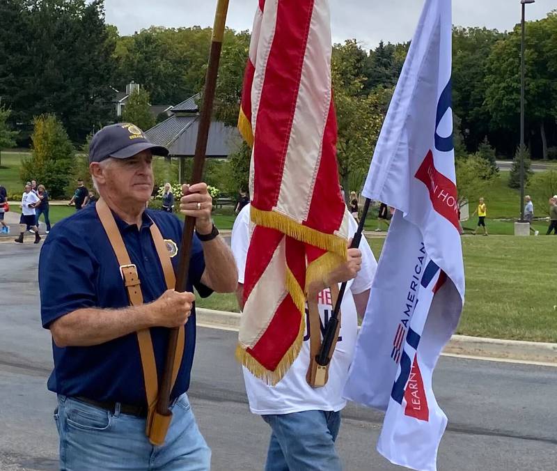 U.S. army veteran Jim Hupke, of DeKalb, who served in the Vietnam War, holds the American flag to lead the Be the One Walk to spread awareness about veteran suicide rates. The 2.2-mile trek to mark the roughly 22 veterans who die by suicide daily set out from Northwestern Medicine Health and Wellness Center, 626 Bethany Road, DeKalb, and drew a large crowd Sunday, Sept. 22, 2024.