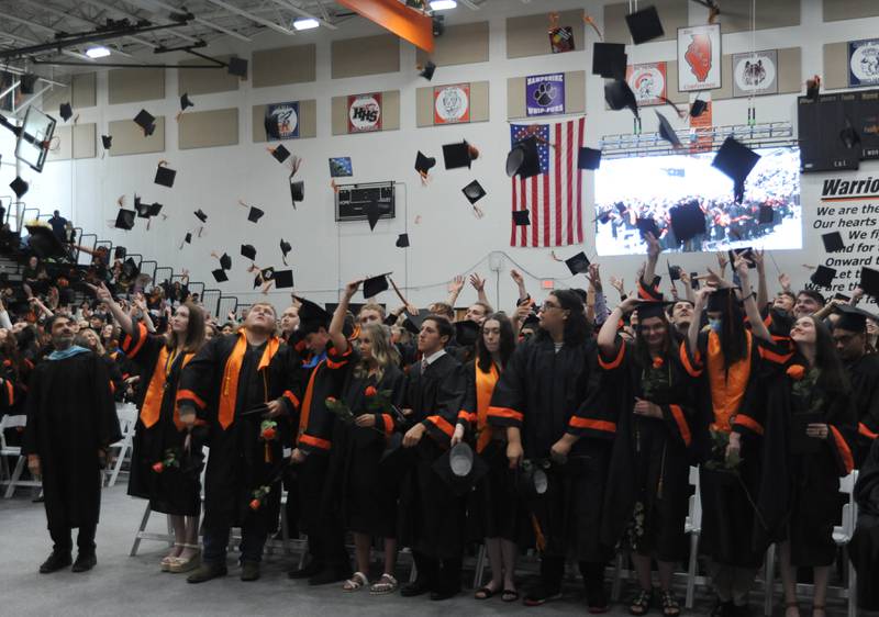 Graduates toss their caps into he air Saturday, May 21, 2022, during the McHenry High School 102nd Commencement Ceremony in the gym of the school’s Upper Campus. The ceremony was moved inside and split into two ceremonies because of the rainy weather.