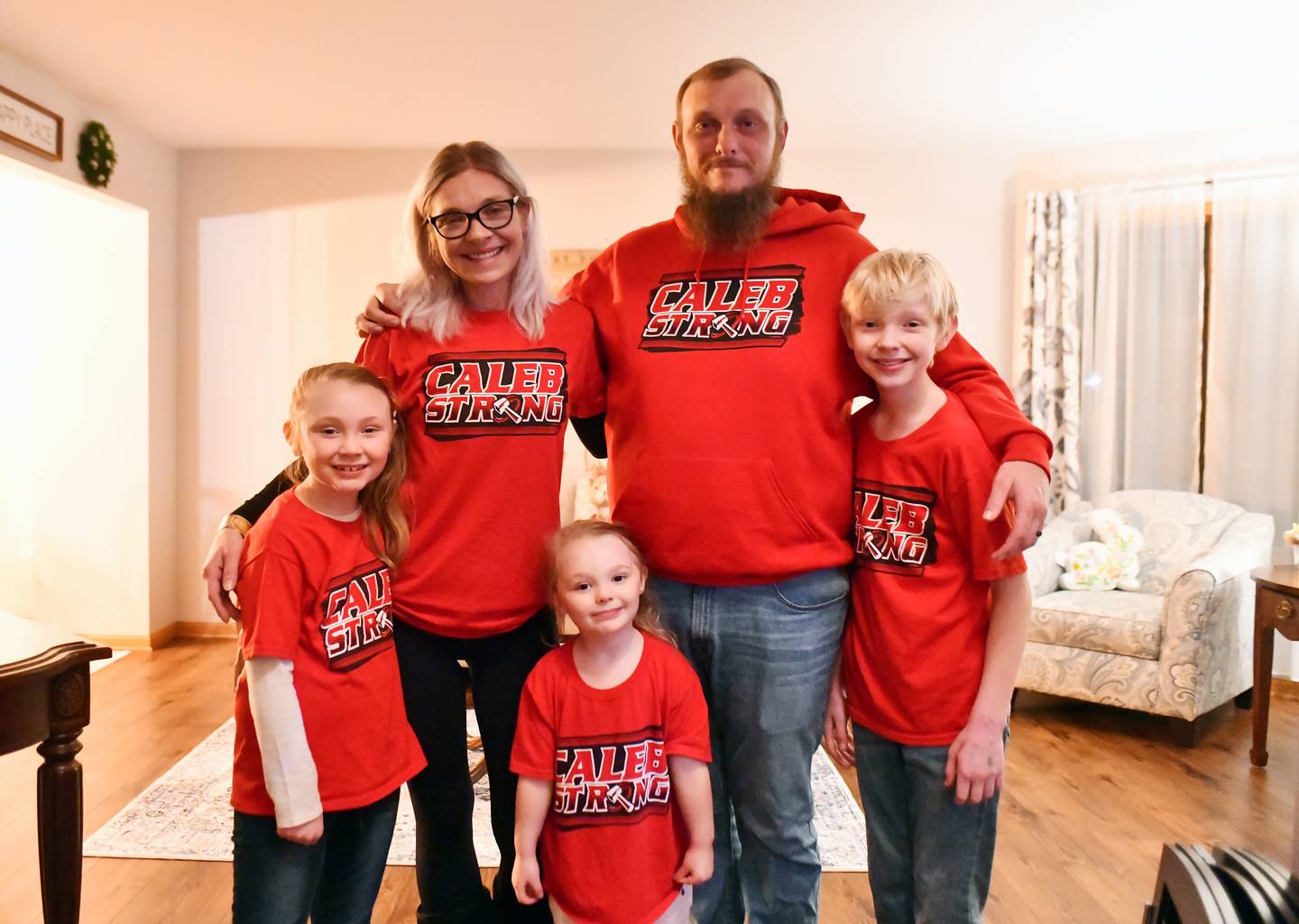 Jennifer and Nick Outerbridge stand with their youngest three children while wearing "Caleb Strong" shirts in support of their eldest son, Caleb, a now 17-year-old BBCHS student, who is battling a rare autoimmune disorder affecting the brain known as ADEM. The family has fought to maintain hope with the help of overwhelming community support.