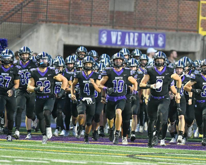 Downers Grove North’s football team takes the field for warmups before taking on Hinsdale Central on Friday Sept. 12, 2025, held at Downers Grove North High School.
