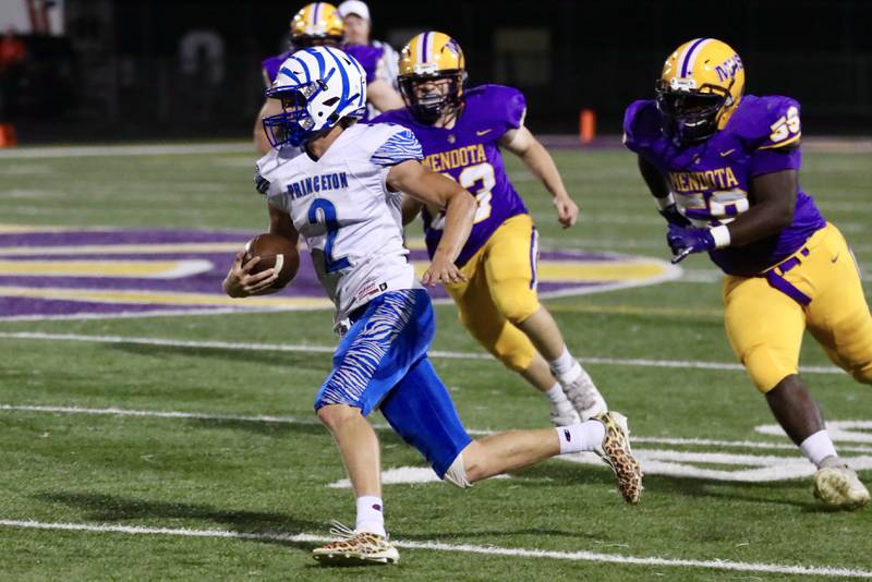 Princeton quarterback Teegan Davis steers clear of Mendota's Logan Muller (23) and Dimitri Rodriquez Friday night.