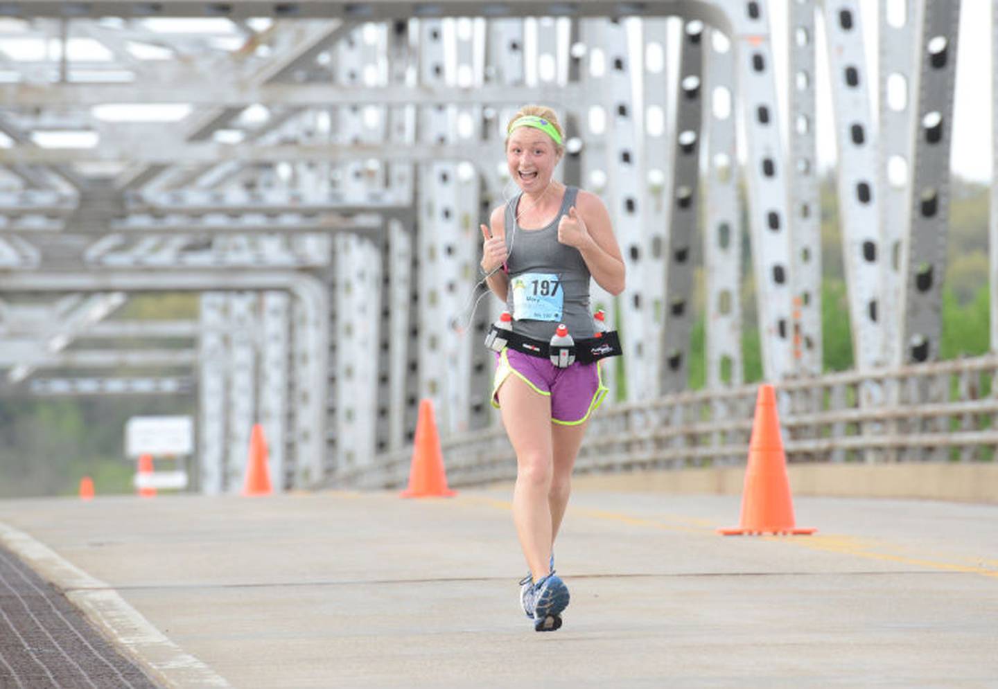 Mary Liesse, of Urbana, Ill., gives a thumbs-up while crossing the Illinois River on the Route 178 bridge near Utica during a past running of the Starved Rock Country Marathon.