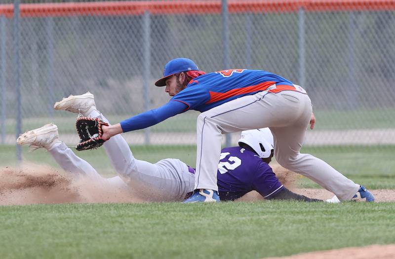 Genoa-Kingston's Christopher Welch takes a throw at first as Rockford Lutheran's Kyng Hughes dives back safely during their game Tuesday, May 2, 2023, at Genoa-Kingston High School.