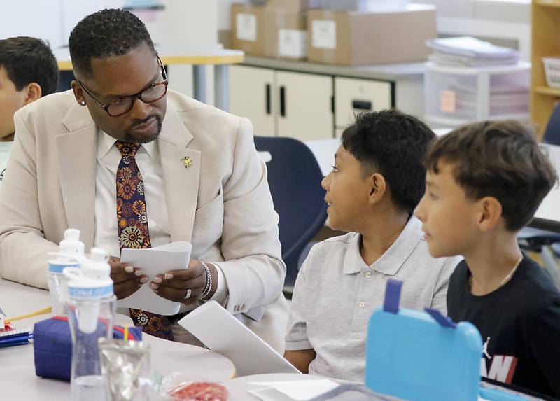 Harvard School District 50 Superintendent Brandon White talks with fifth grade students Anthony Juarez and Alexis Mercado  at Jefferson Elementary School during the first day of school on Wednesday, Aug. 13, 2025, in Harvard. White was previously was the superintendent of Cary School District 26.