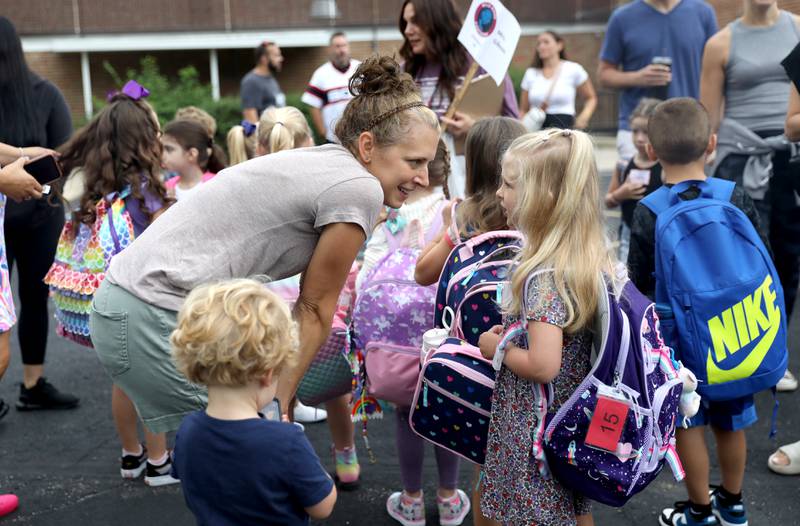 Ellen Johnson chats with her daughter, Lorelai, as her son, Ben, 2, looks on as they line up for the first day of school at Wild Rose Elementary School in St. Charles on Monday, Aug. 14, 2023.