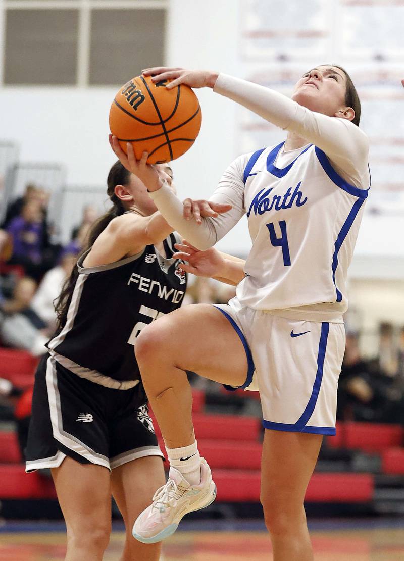 Fenwick's Madison Zorovich (22) fouls St. Charles North's Hannah Ganser (4) on her way to the basket during the Dundee-Crown High School 41st Annual Komaromy Classic Friday, Dec. 27, 2024 in Carpentersville.
