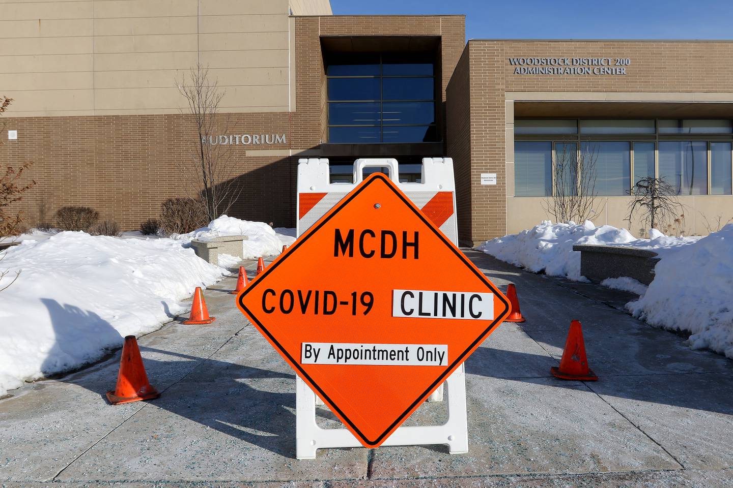 A sign designating the vaccination entrance points toward the Woodstock District 200 Administration Center during a vaccination clinic for staff with Woodstock Community Unit School District 200 and Johnsburg School District 12 at Woodstock North High School on Thursday, Feb. 11, 2021 in Woodstock.  The clinic is hoping to vaccinate 2,600 employees of school districts in the northern half of McHenry County with the Moderna COVID-19 vaccine over the course of Thursday and Friday.